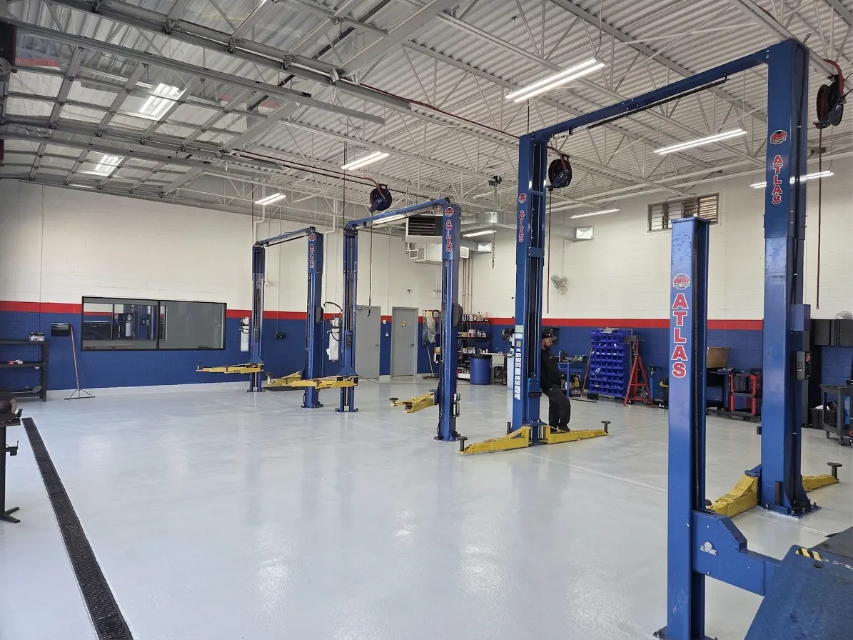 Empty service bays with blue lifts and the red and blue shop wall
