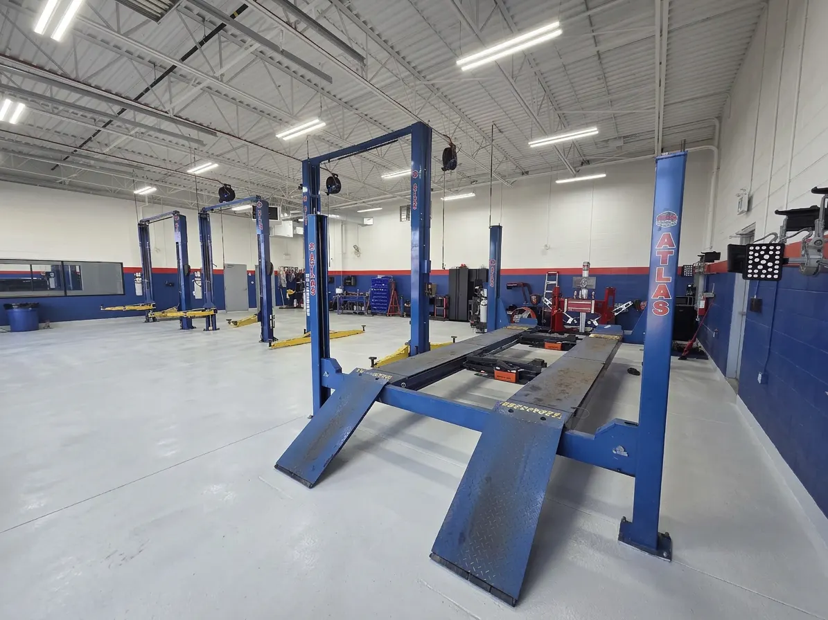 Blue four-post alignment lift with alignment targets in the dedicated alignment bay